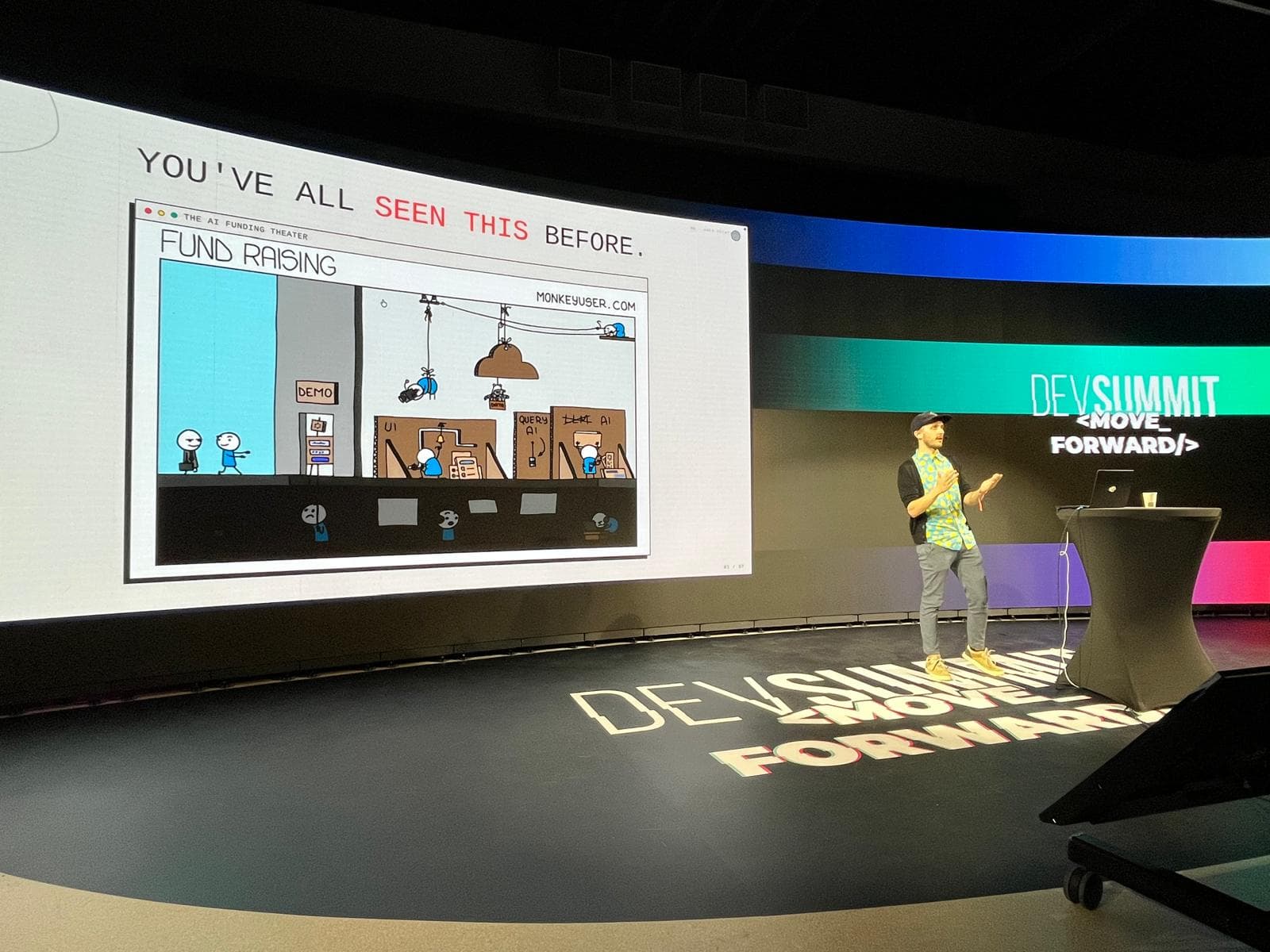 Mehdi giving a talk on a large conference stage