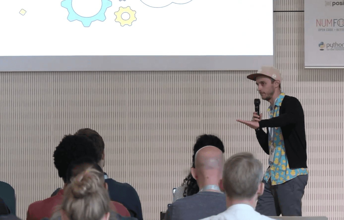 Mehdi speaking with a microphone to an audience